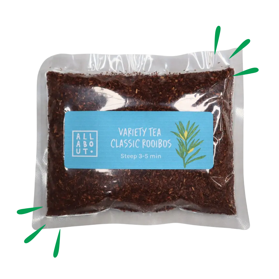 All About Kombucha variety tea pouch labeled Classic Rooibos in a clear pack with blue label, filled with finely cut red rooibos leaves and a botanical illustration.