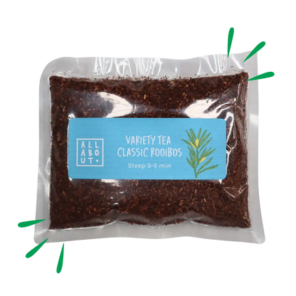 All About Kombucha variety tea pouch labeled Classic Rooibos in a clear pack with blue label, filled with finely cut red rooibos leaves and a botanical illustration.