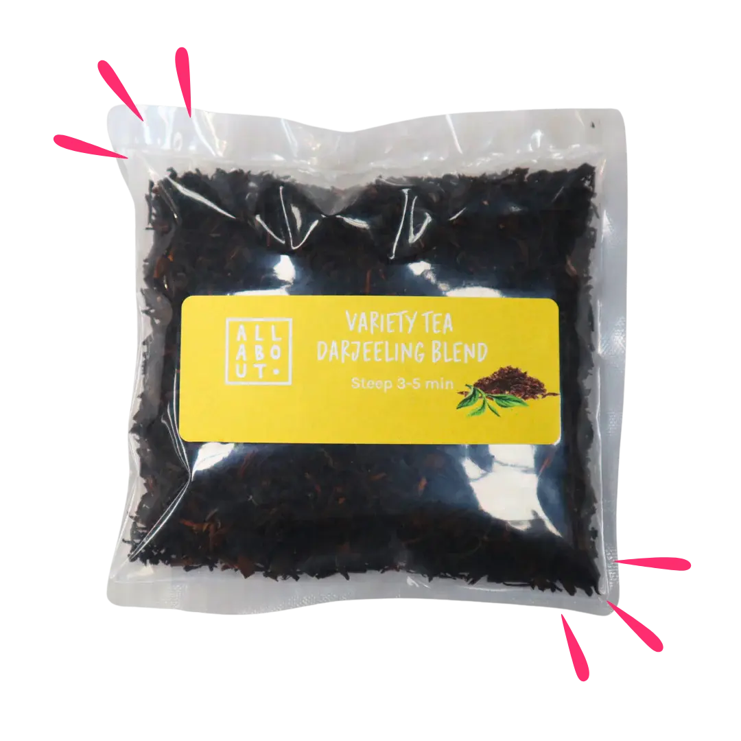 All About Kombucha variety tea pouch labeled Darjeeling Blend in a clear steeping pack with yellow label, filled with dark loose leaf tea and a tea leaf illustration.

