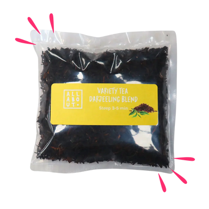 All About Kombucha variety tea pouch labeled Darjeeling Blend in a clear steeping pack with yellow label, filled with dark loose leaf tea and a tea leaf illustration.

