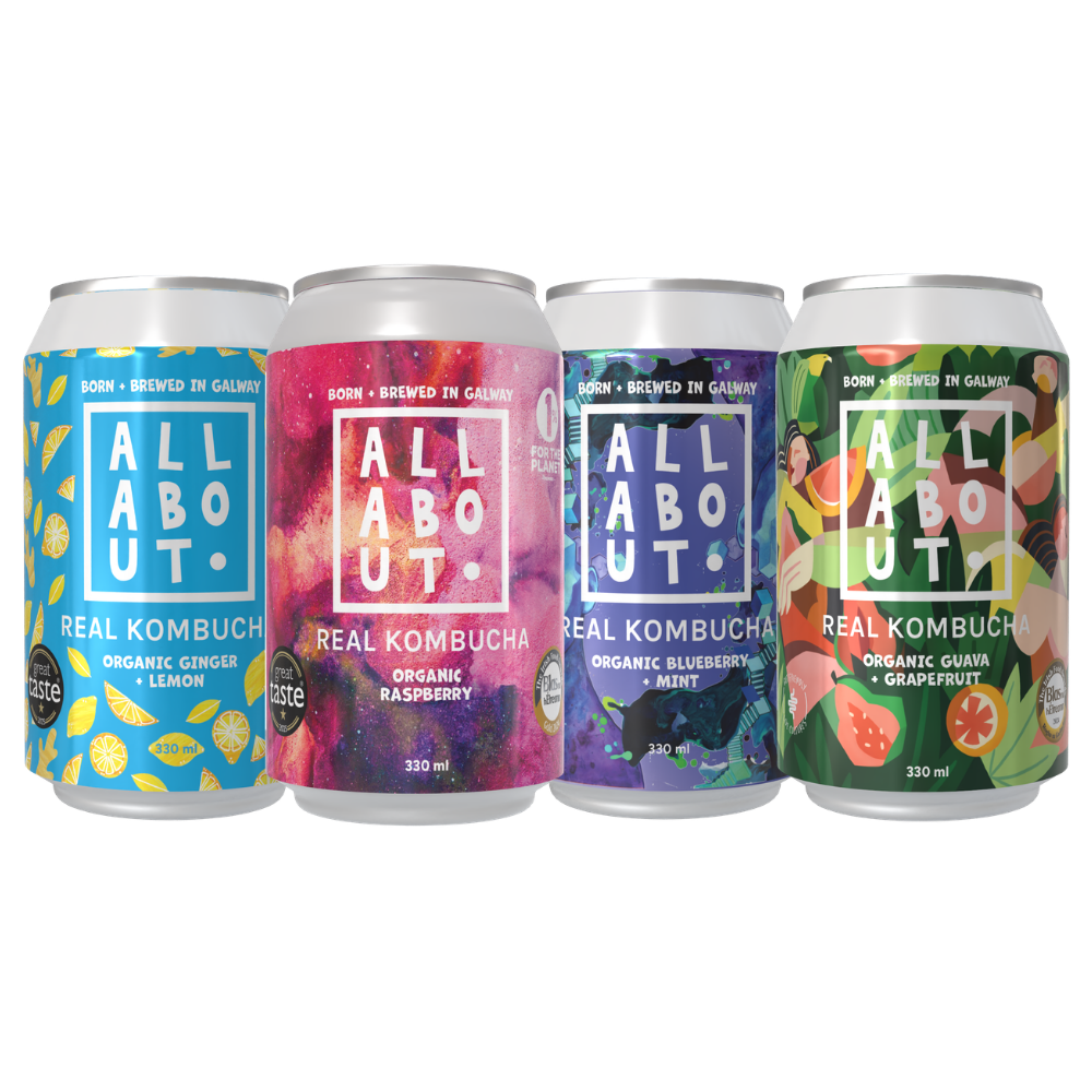 Four aluminum cans of All About Kombucha arranged side by side on a white background. The labels feature colorful fruit and flavor designs: blue lemon, pink raspberry, purple mint, and green guava/grapefruit.